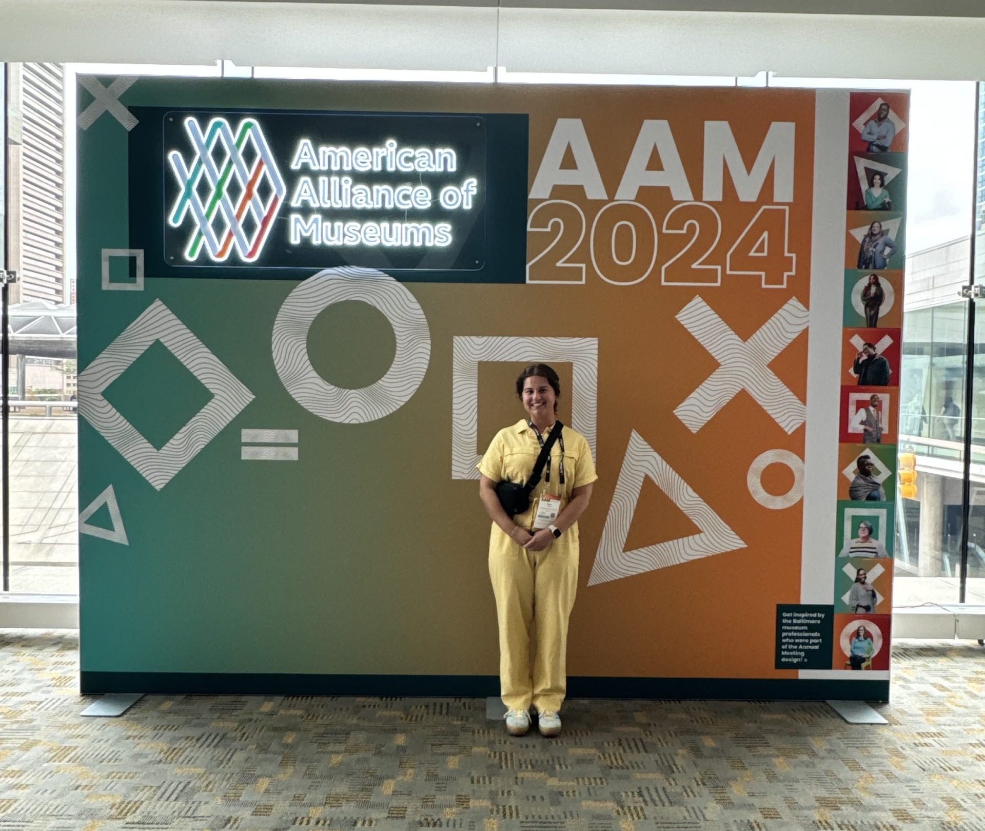 Bryce standing in front of an American Alliance of Museums 2024 Museum Expo backdrop.