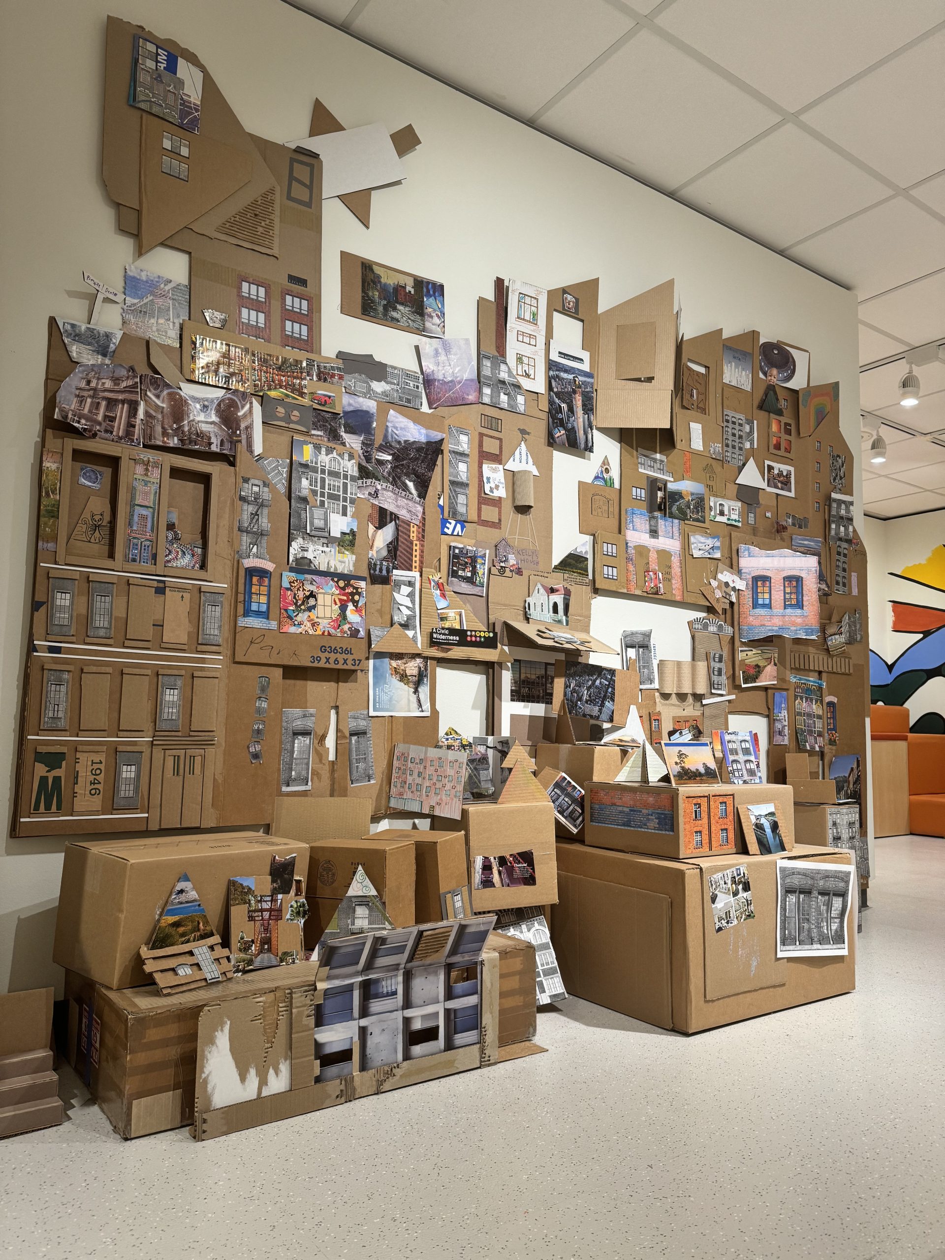 A cardboard cityscape project displayed in Art Park that visitors have contributed to.