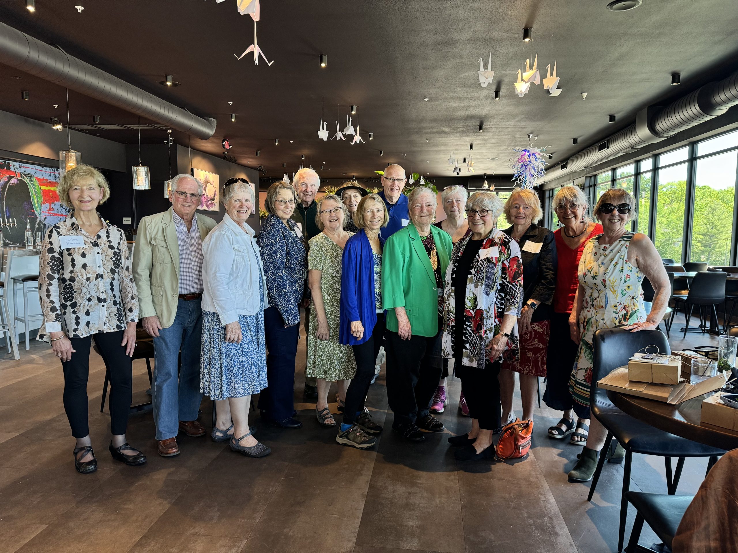 A smiling group of Museum docents stand together at the Velveteen Plum