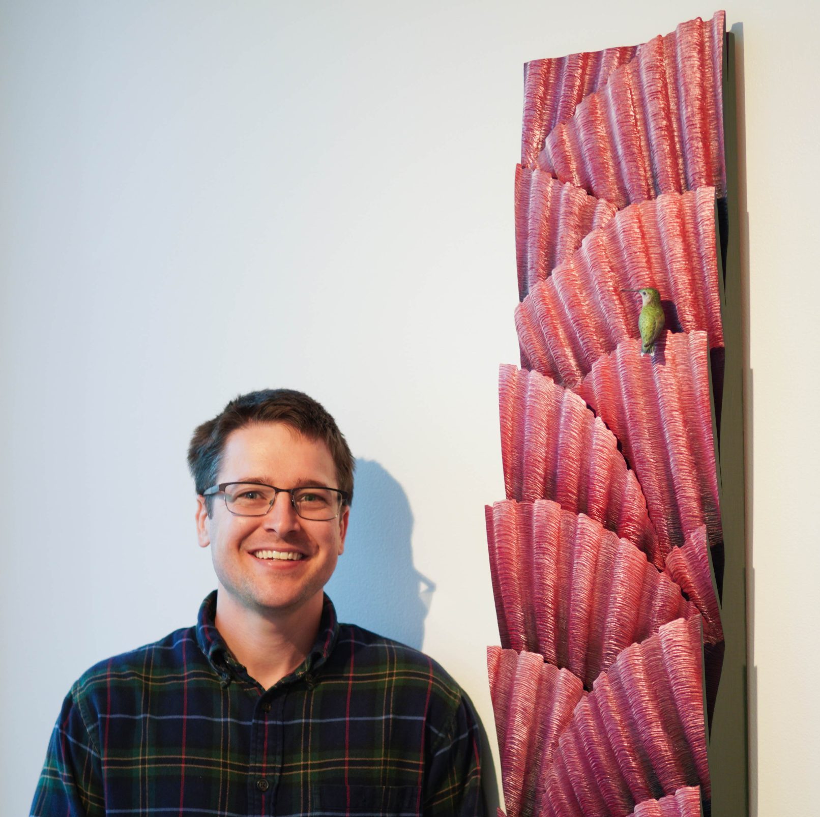 "Birds in Art" artist Spencer Tinkham standing next to his work from "Birds in Art' 2024.