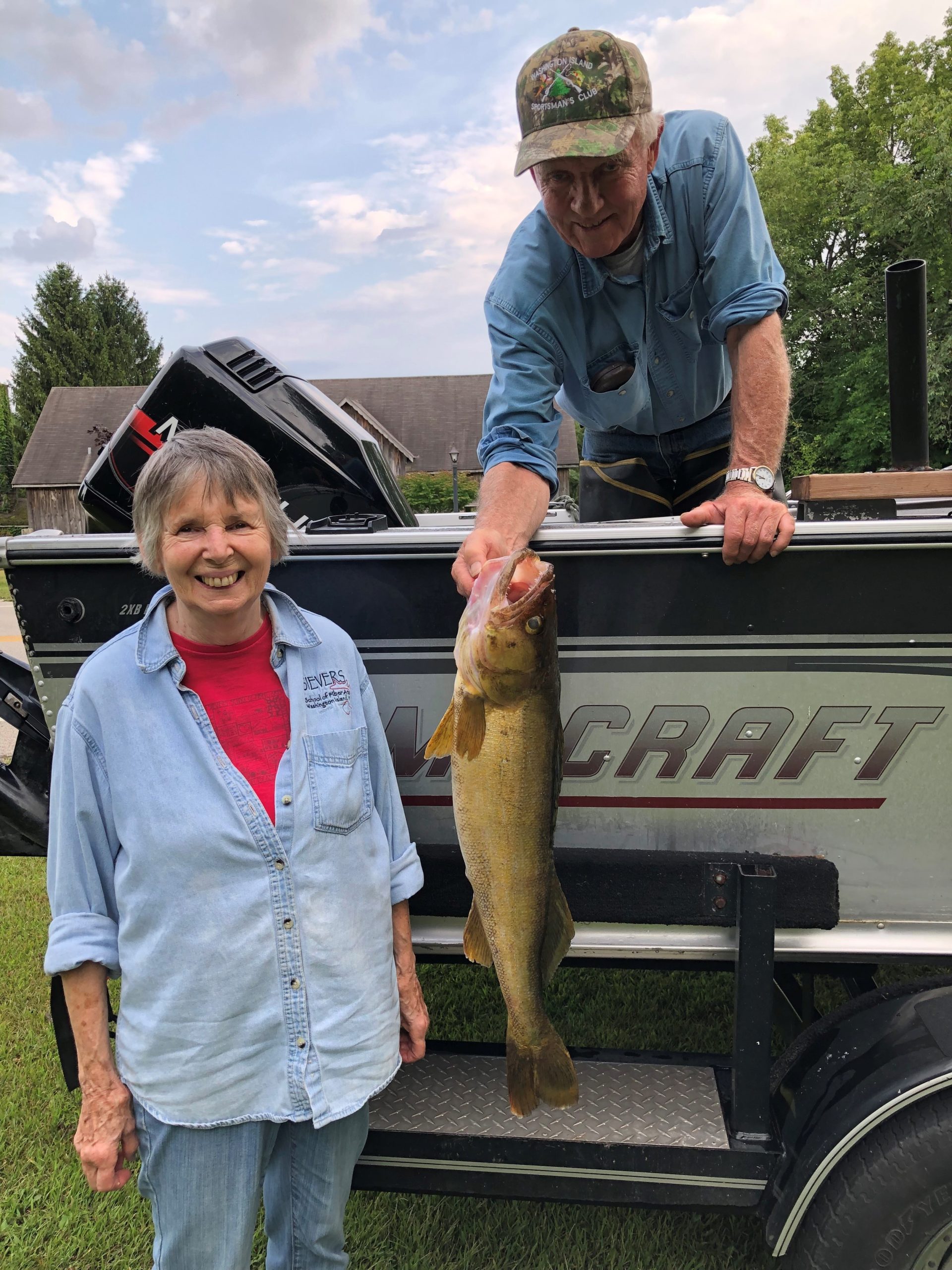 This image shows a woman and a man with the man holding a large walleye