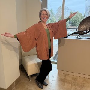 Woman stands with hands out as she wears a kimono